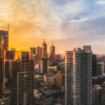 Stunning view of Melbourne's skyline at sunset, capturing modern skyscrapers and warm sky.