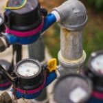 Detailed image of industrial water pressure gauges and pipes in an outdoor setting.